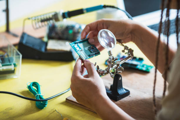 close up of female hands holding circuit board at workshop